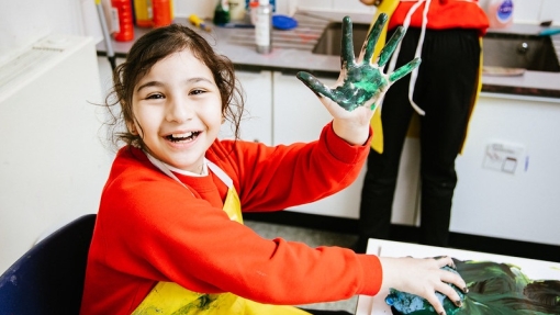 girl with paint on hand having fun