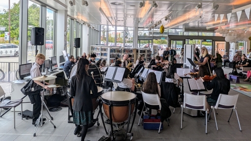 A school orchestra performing in a community hub.