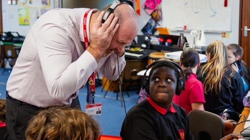  Teacher listening to children play musical instruments