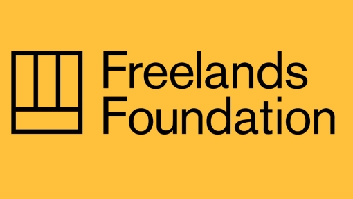 Logo on a yellow background featuring the text 'Freelands Foundation' in black, accompanied by a black geometric design of three vertical lines and one horizontal line forming a rectangular shape to the left of the text.