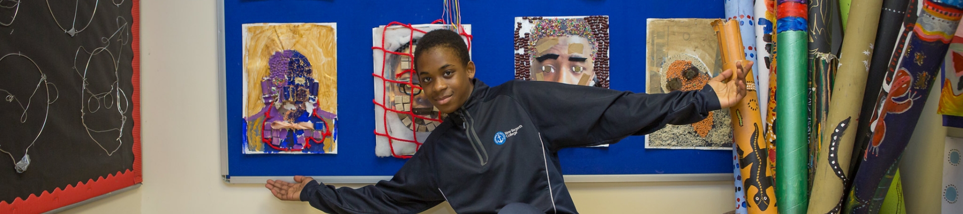 Young male with arms open, displaying his visual art work