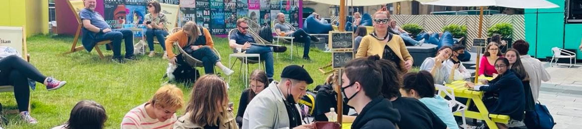Students from Bolton school sitting at a bench outside at Manchester International Festival 