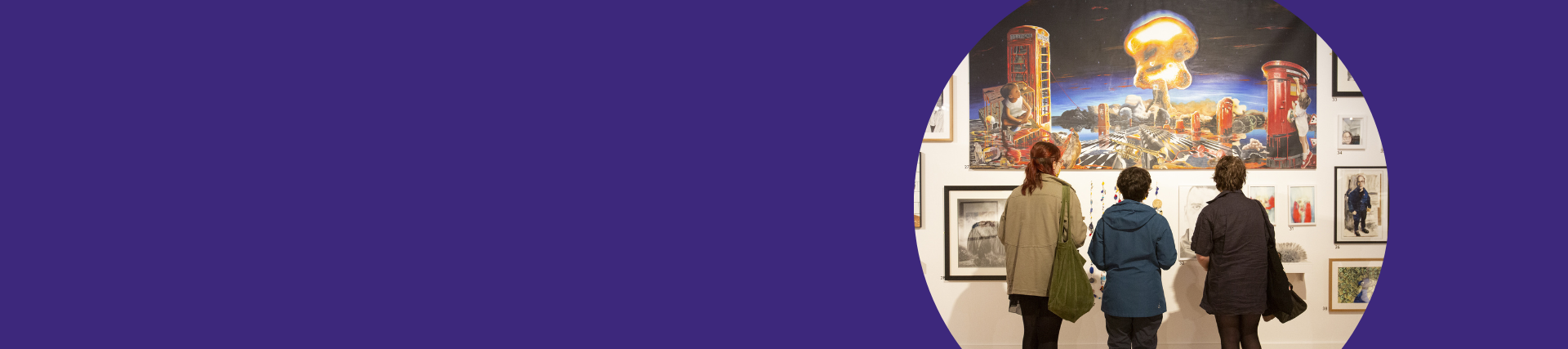 Three students looking at artworks on a wall