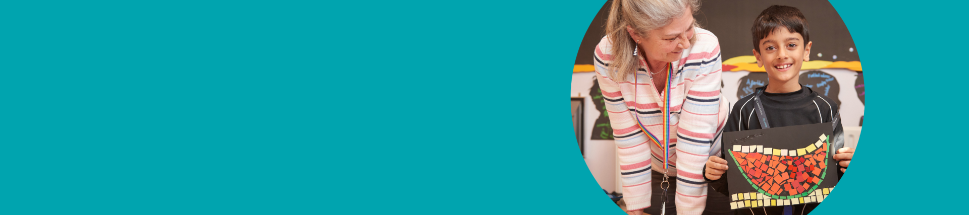 A turquoise banner with an image on the right of a teacher standing next to a boy proudly holding up his artwork 