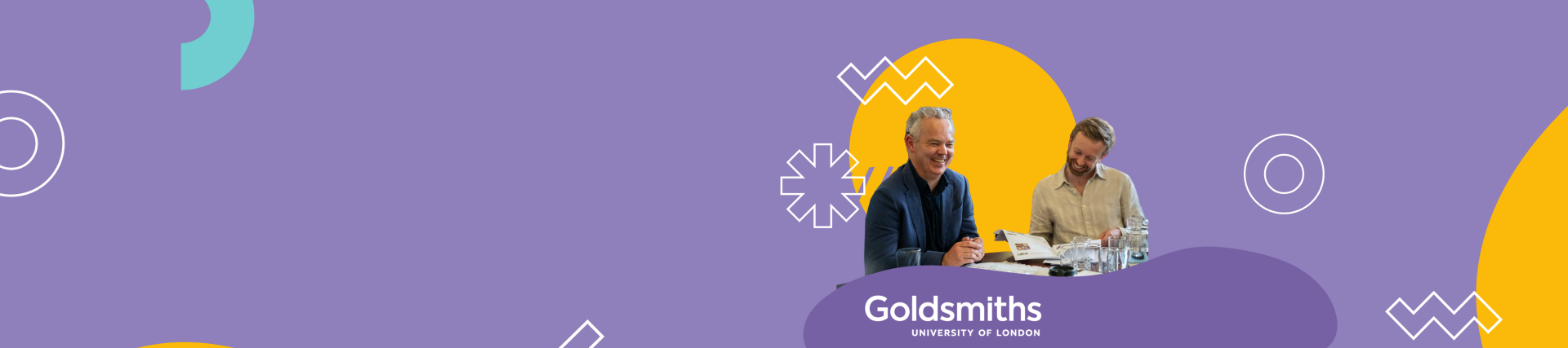 A purple banner with two men sitting at a table with papers in hand, smiling