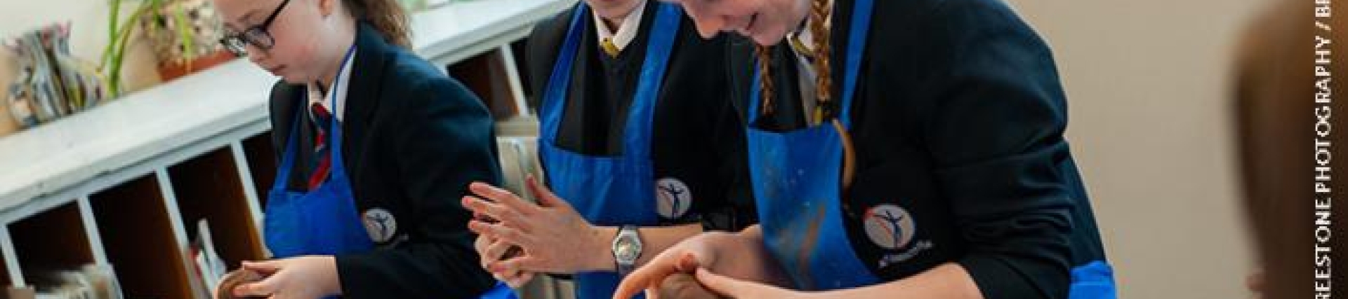 Girls making clay models and smiling