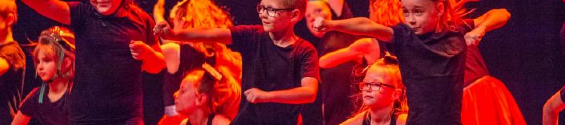 Young people dancing on stage with red light glowing 