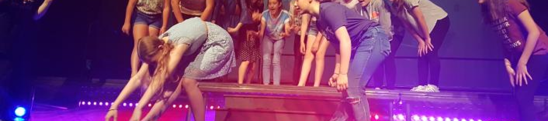 A group of secondary students dancing on stage