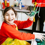 girl with paint on hand having fun