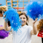A girl dancing with blue pompoms 