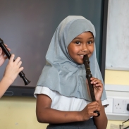 A young girl playing recorder