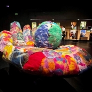 A dark room with bright sculptures lit up in the centre