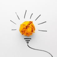 Crumpled yellow paper centered on a white background, surrounded by black lines forming rays and a light bulb base, resembling a light bulb illustration