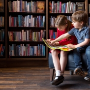 Two children reading a book in a library