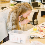 Young person demonstrating methods of tote bag decoration as part of a YOT project at Tate Exchange