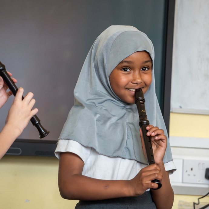 A young girl playing recorder